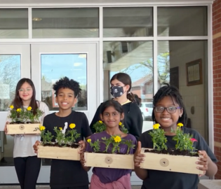 Students holding garden boxes