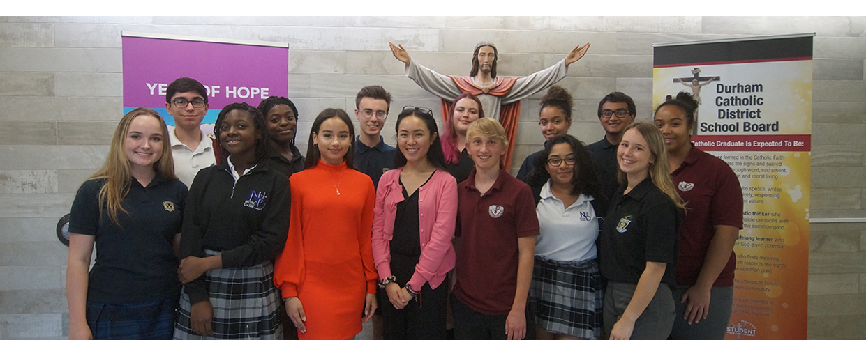 Male and female members of the 2019-2020 Student Senate standing in front of a statue of Jesus