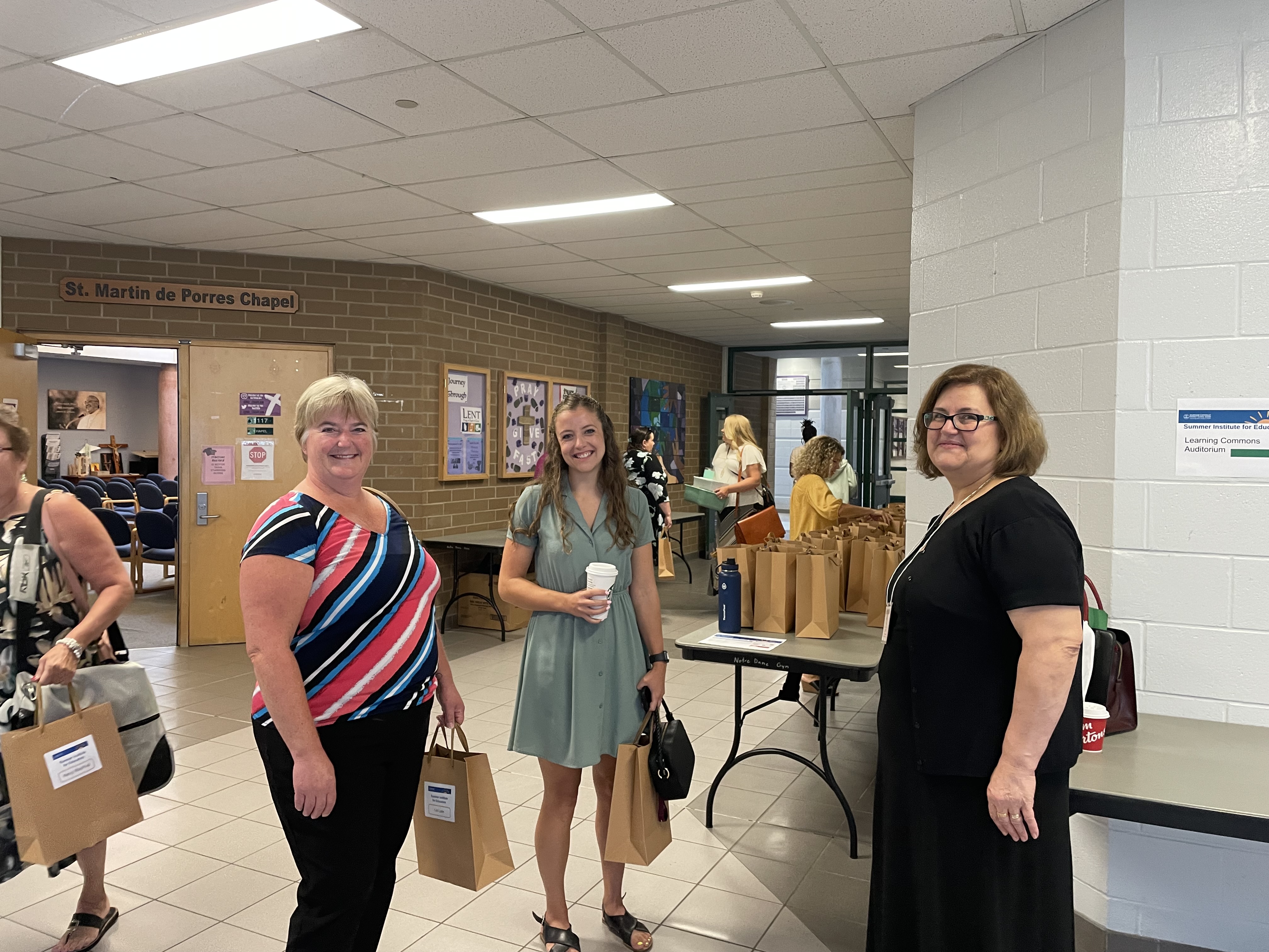 Three female staff members arriving for the Summer Institute for Educators session