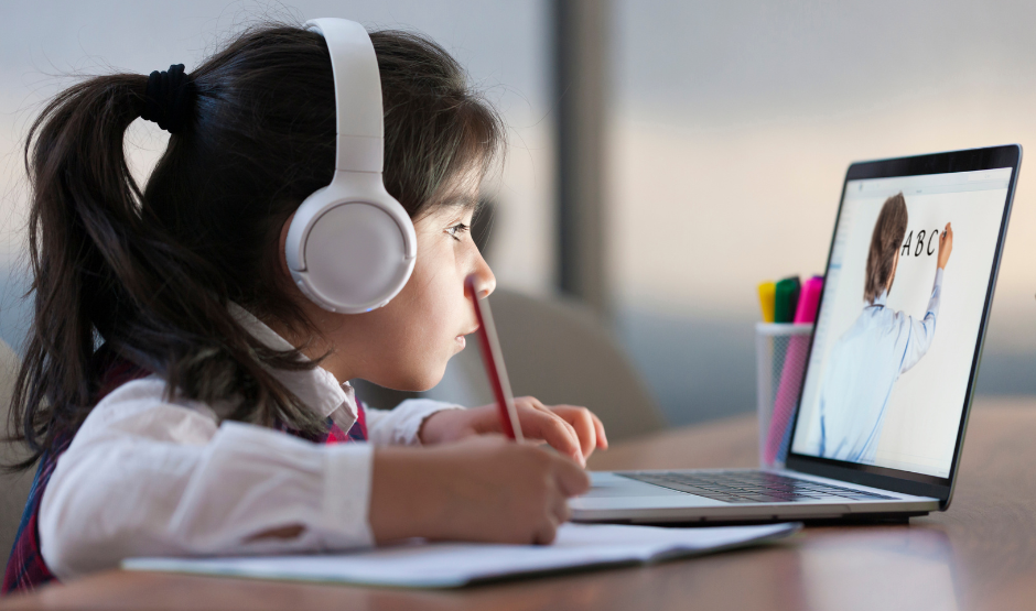 a girl wearing headphones looking at a laptop