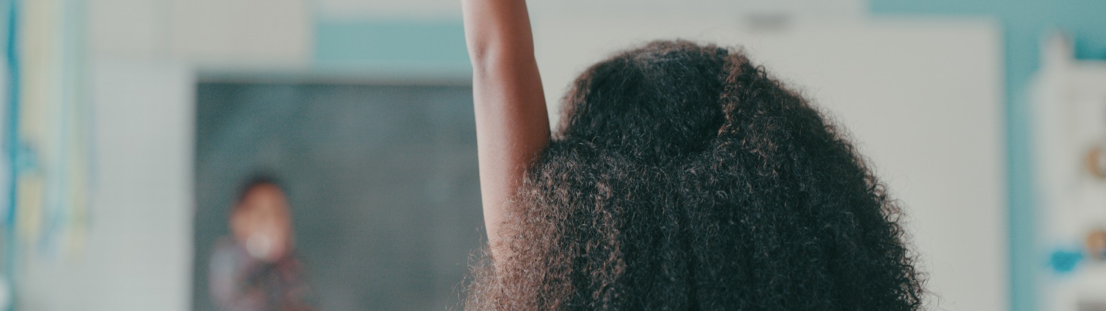 Student holding her hand up in class