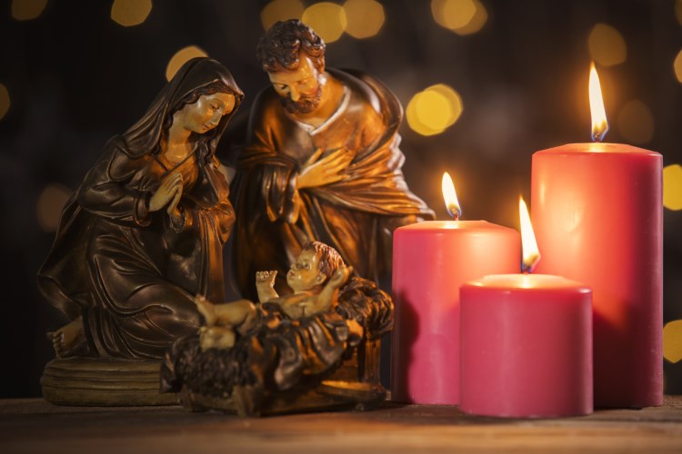 Mary, baby Jesus, and Joseph figures by three candles