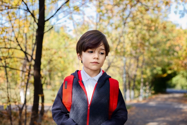 photo of a young boy outside looking a little sad