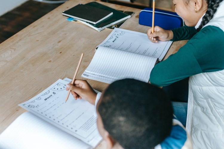 two students writing in their books