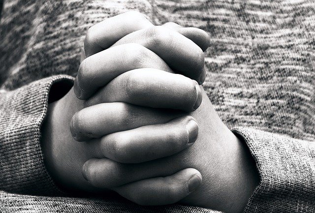 black and white photograph of hands in prayer 