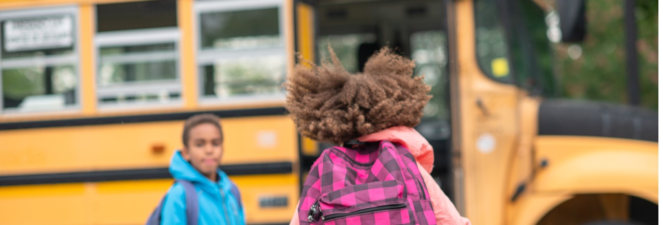 student running towards bus doors