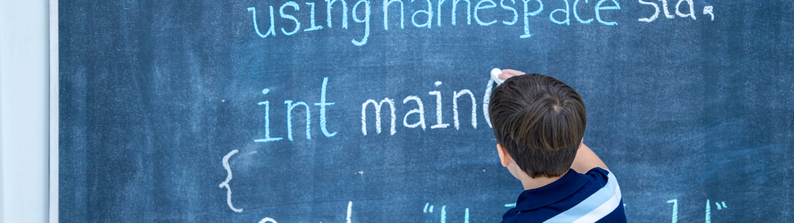 Student writing on chalkboard 