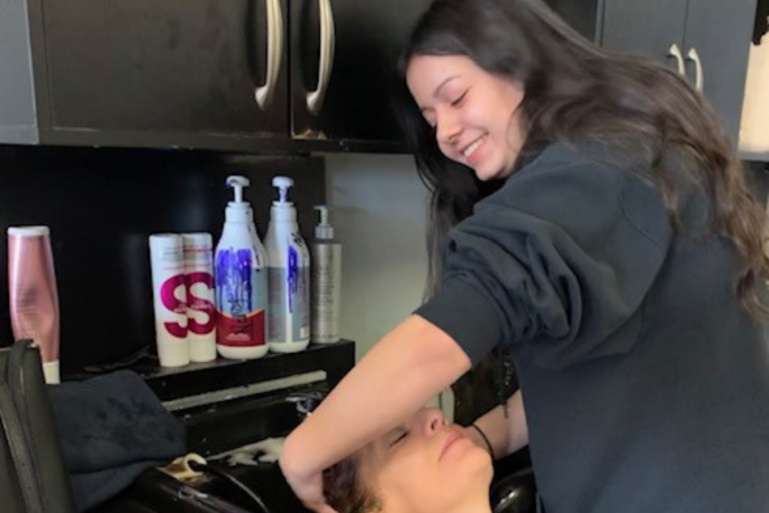 Student washing customer hair