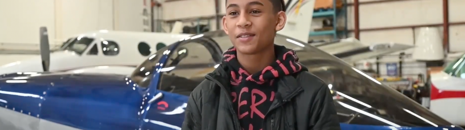 student standing in front of airplane