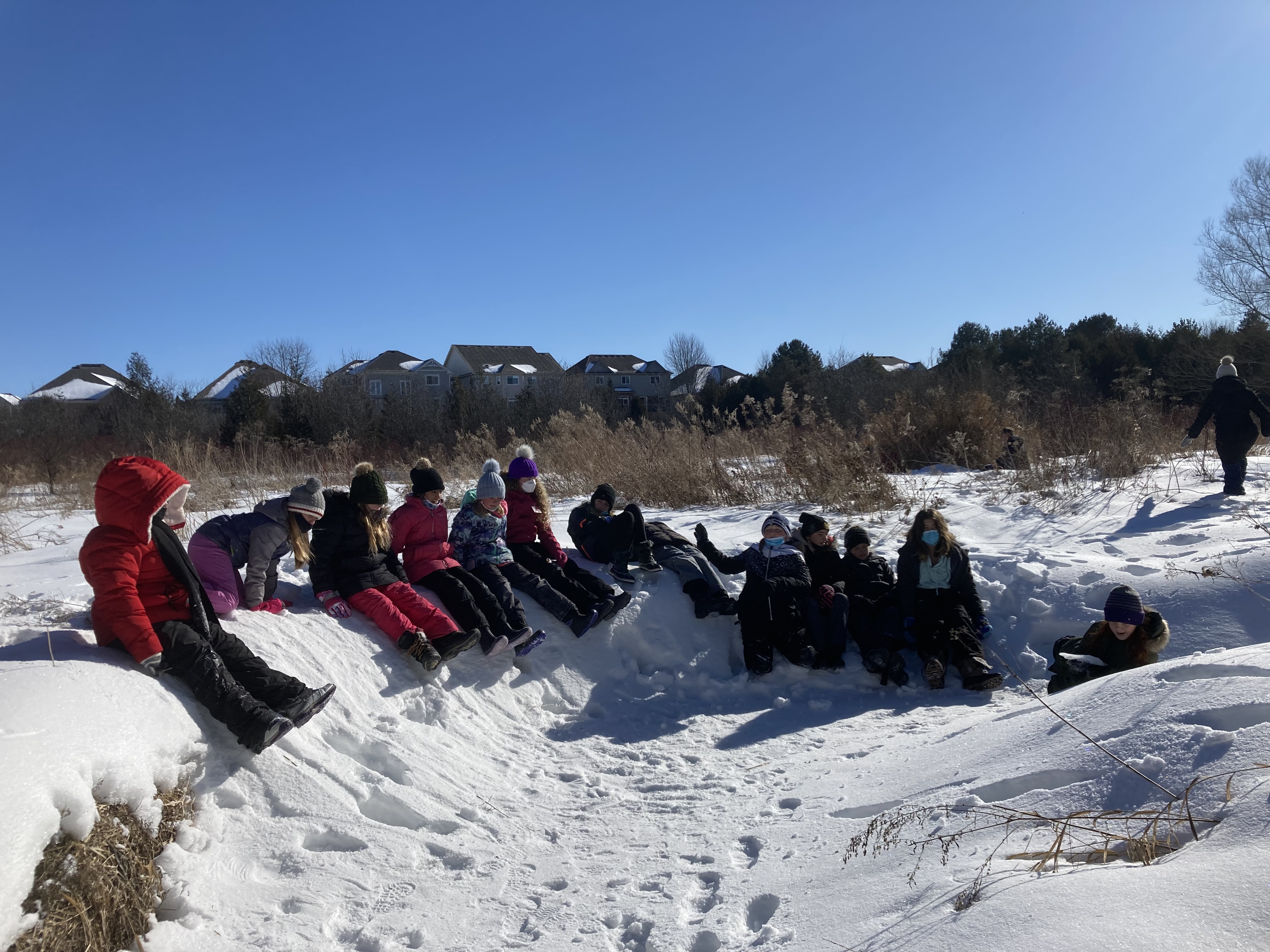 students sitting on snow outside