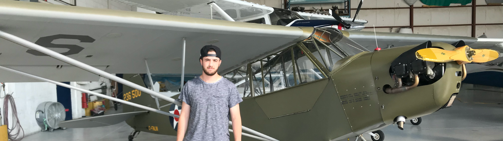 student standing in front of airplane