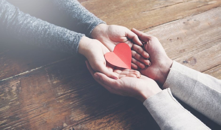 Hands holding red paper heart