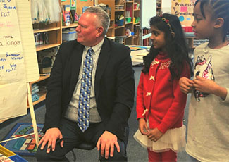 Male adult listening to two female students