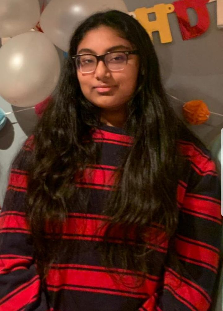 photograph of a female student with balloons behind her