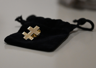 Photo of a pin that is in the shape of a cross