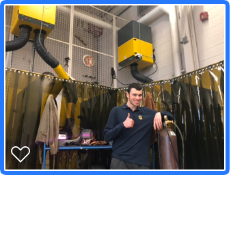 Male student giving the new welding booths a thumbs up