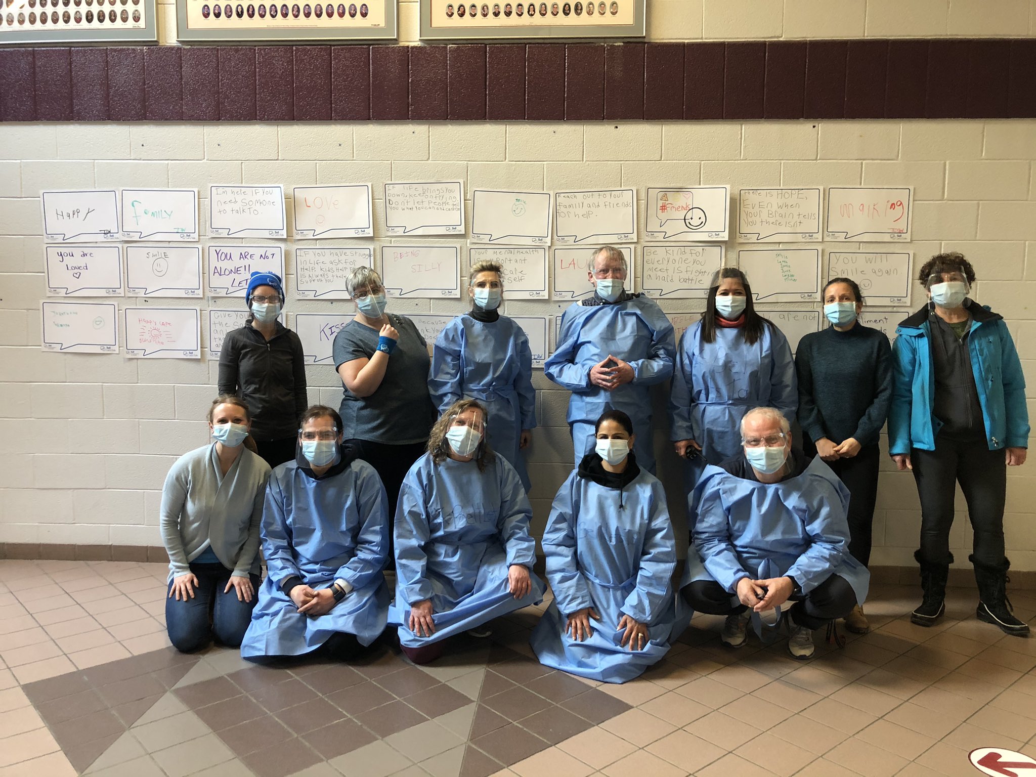 Image of a group of adults in gowns with masks on