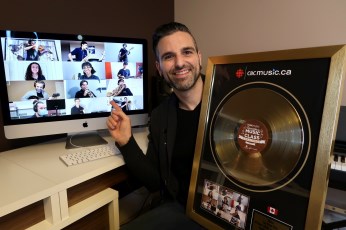 Image of a man holding an award featuring a vinyl record on it