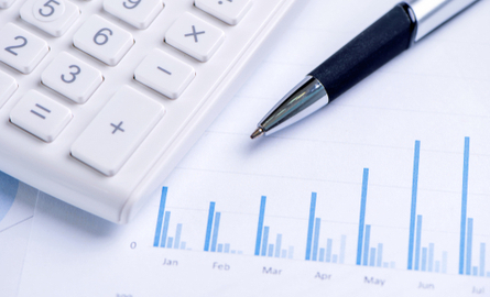 Photo of a calculator and pen laying over a document