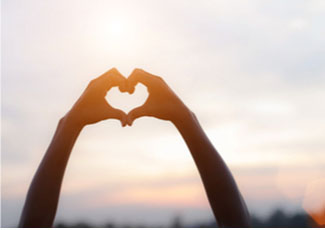 hands forming a heart in the sky