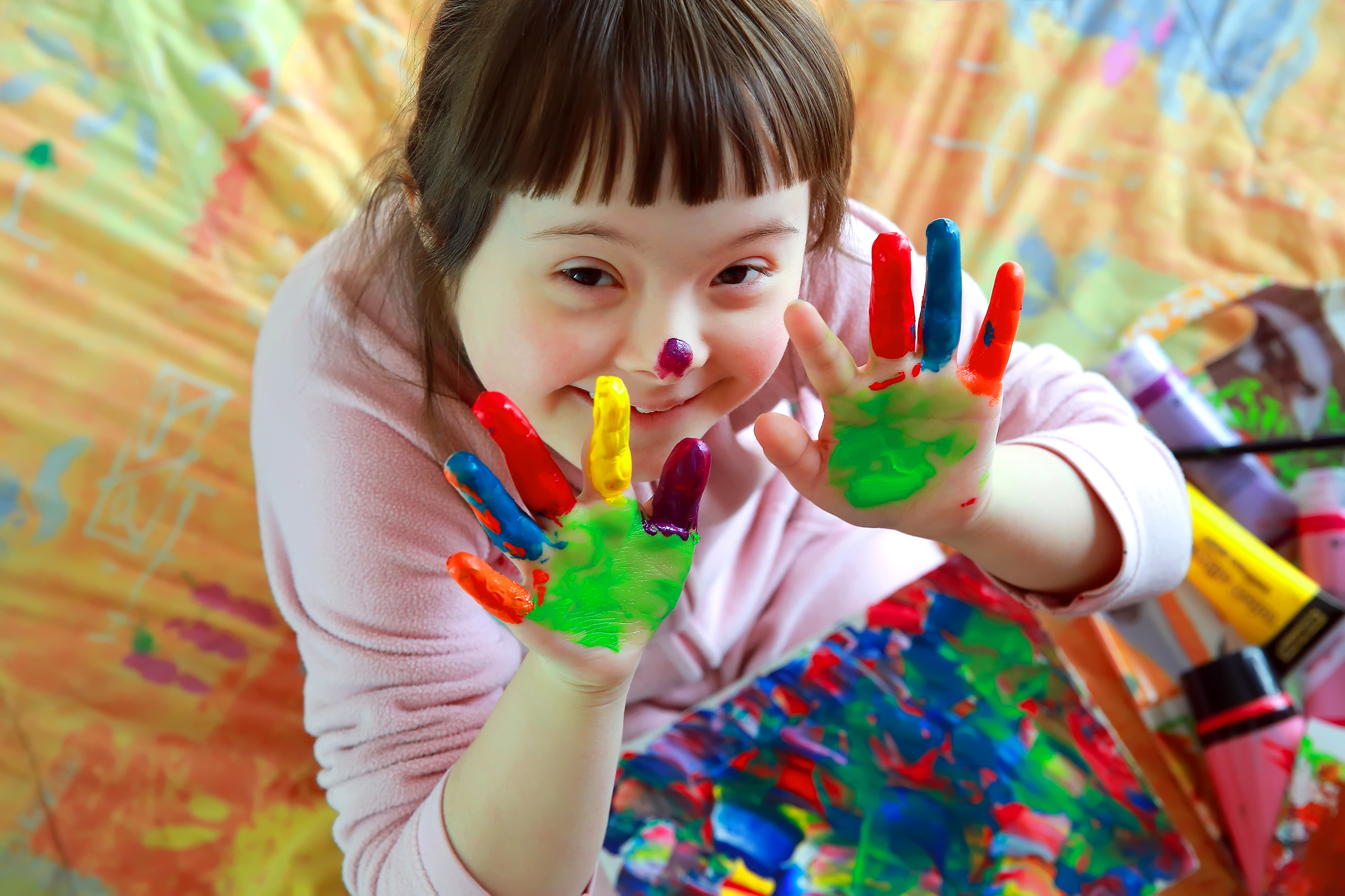 female student with hands covered in paint