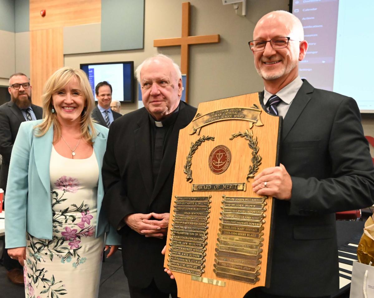 Director of Education and Chair of the Board present Father Keith with the Board Award of Merit