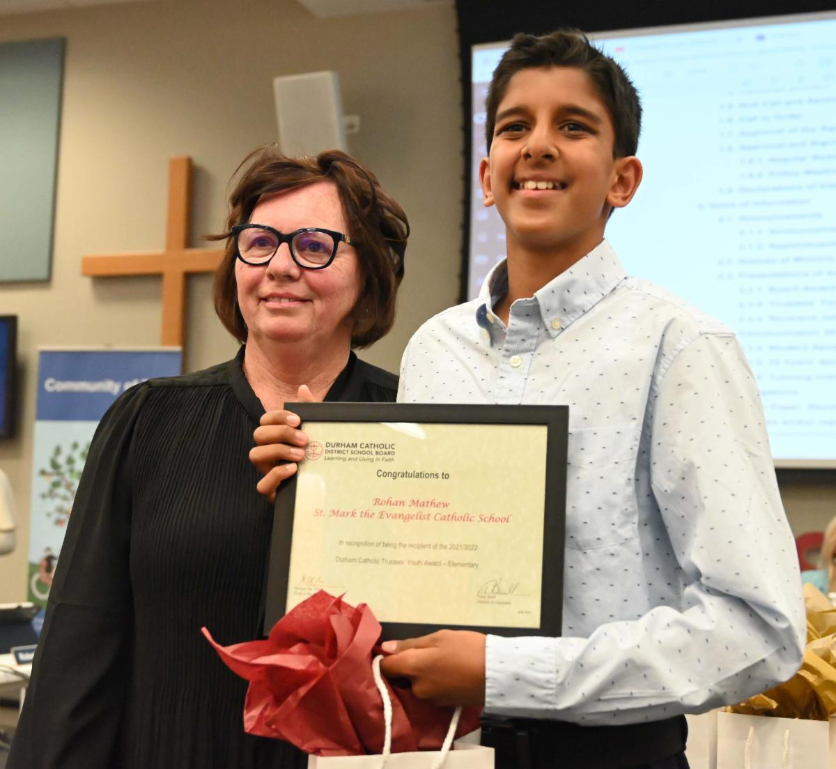 Trustee Oldman presents Trustee Youth award to male student