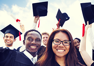 Male and female students in graduation gowns and caps in the air