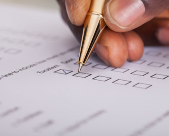 hand holding pen completing a paper survey