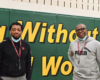 Two male educators in a school's gym