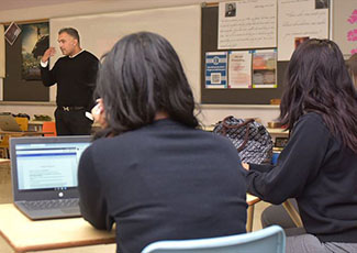 Male educator talking to students in a classroom
