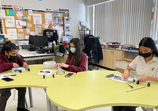 Students building OYAP cars in a classroom