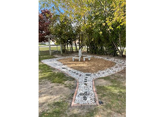 Statue of Mary Mother of God and two benches in the school's rosary garden