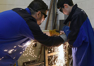 Male educator helping student with grinder