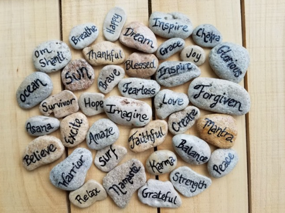 stones with positive words written on them in black ink