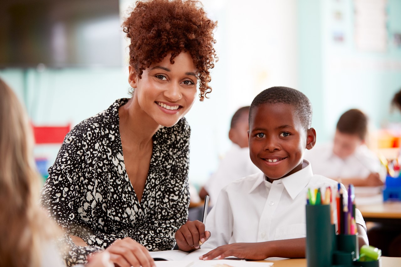 Female adult with male student in a classroom