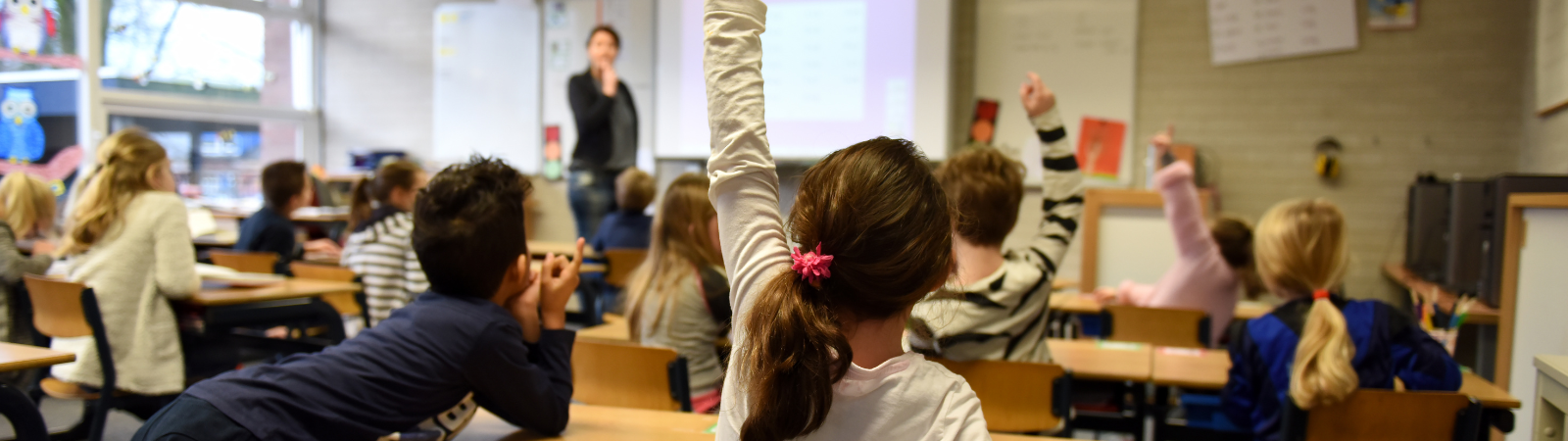 Children raising hands in a classroom