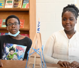 Students with a popsicle stick structure