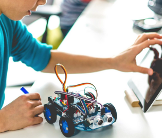 Young boy coding with robots