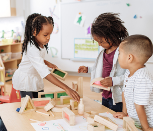 Children playing at a table in a classroom