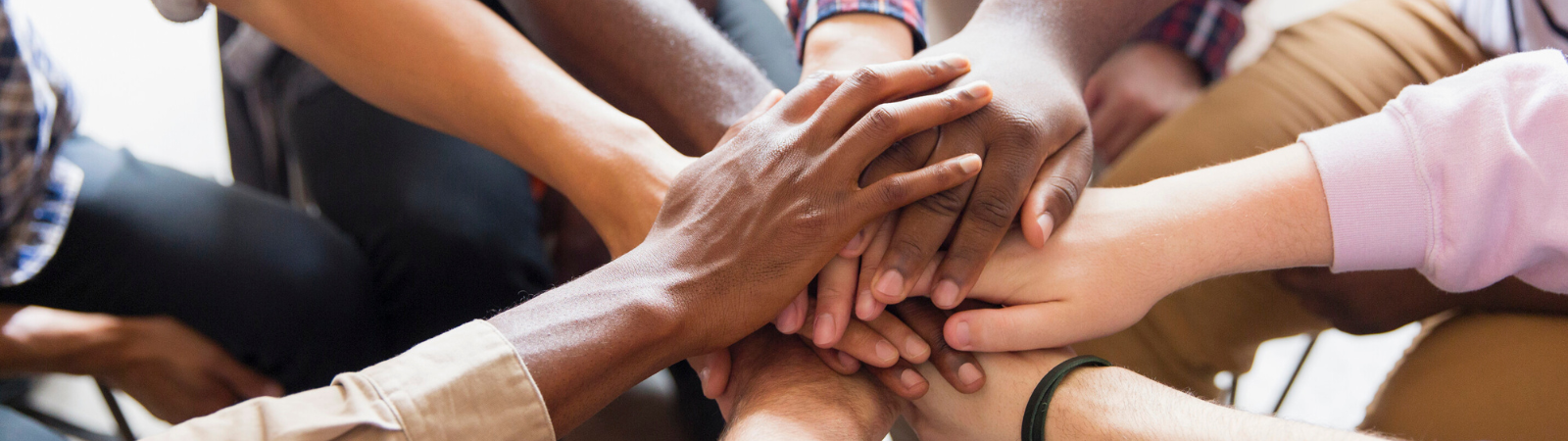 Multiple hands coming together and stacking on one another