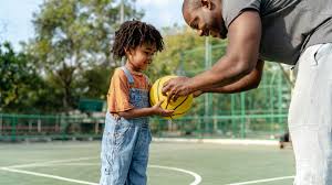 Father handing a basketball to son