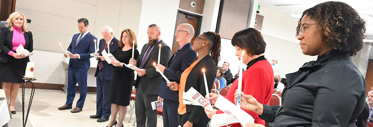 Board of Trustees holding candles as part of their Declaration of Service