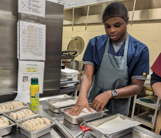 male student working in a kitchen