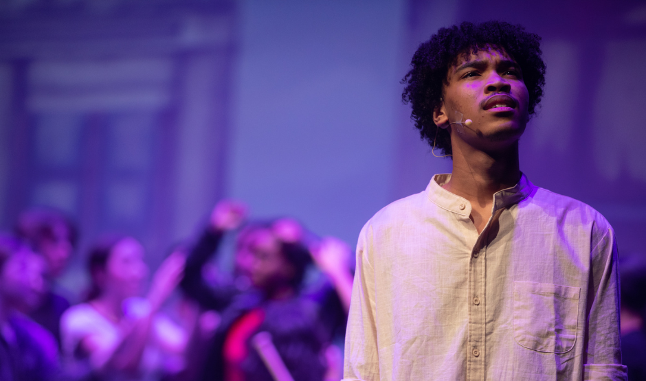Teen male singing on a stage