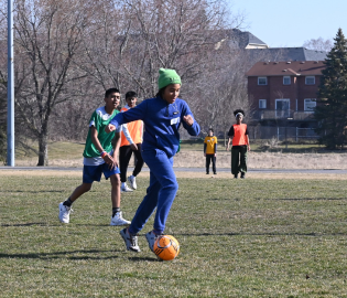 Young student kicking a soccer ball