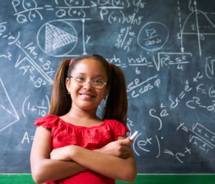 Young girl standing in front of a chalkboard