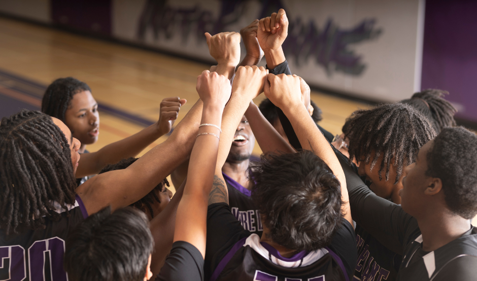 Sports team raising hands together