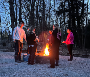 group of people standing at a fire