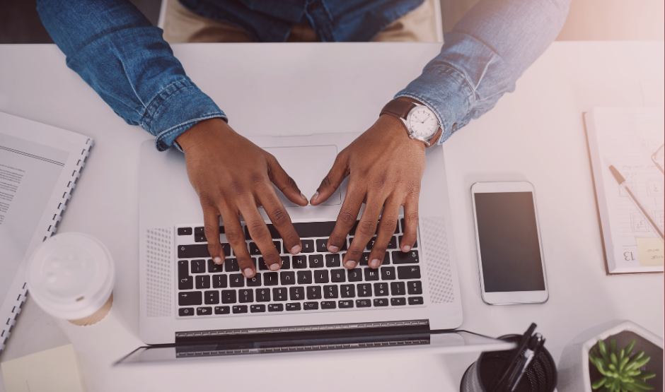 man typing on a laptop